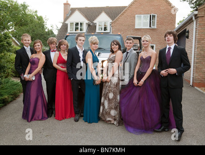 Teenager-Mädchen und jungen verkleideten sich bereit für ihre Schule Abschlussball Pose vor ihre Limo, Cambridgeshire, Großbritannien Stockfoto