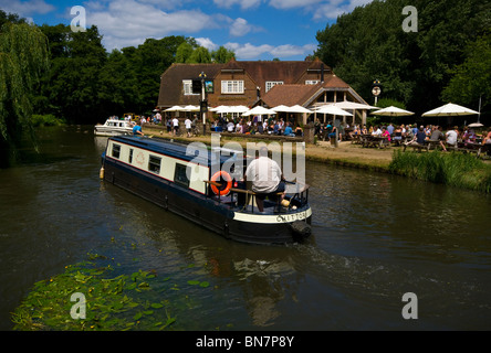 Eine schmale Kanalboot Narrowboat Passing The Anchor Pub auf der Fluss Wey Pyrford Surrey England Stockfoto