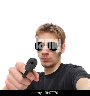 Ein junger Erwachsener hält den Betrachter mit vorgehaltener Waffe. Isoliert auf weißem Hintergrund. Stockfoto