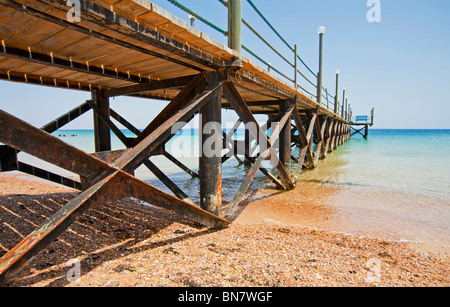 Einen kleinen Holzsteg ins Meer gehen, von einem tropischen Strand Stockfoto