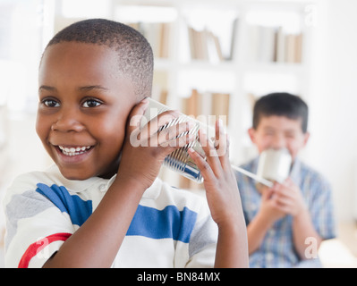 Jungs spielen mit Blechdose Telefon Stockfoto