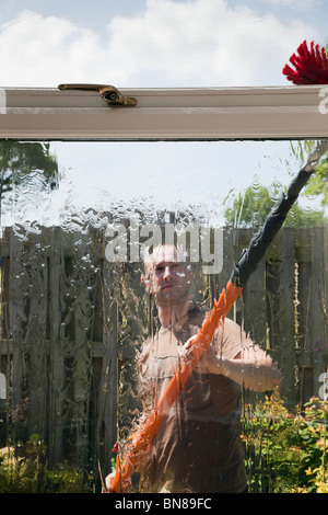 Fensterreiniger außen mit einem soapless reines Wasser gefüttert Pole und Pinsel Fensterreinigungs-System für sauberes Glas von innen gesehen Stockfoto