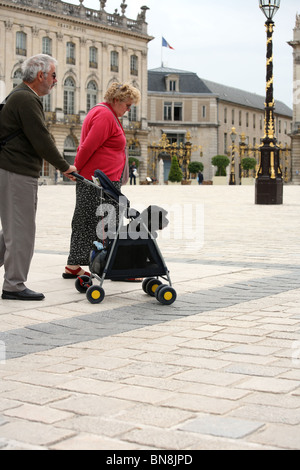 Ein älteres Ehepaar mit einem Hund in die Place Stanislas, Nancy, Frankreich Stockfoto