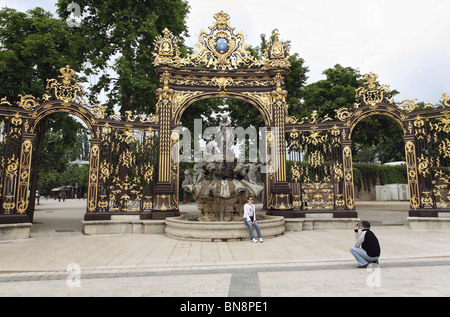 Ein paar vor der Amphitrite Brunnen auf der Place Stanislas, Nancy, Frankreich Stockfoto