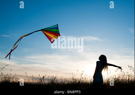 Junges Mädchen Spaß bunte Drachen in der englischen Landschaft. Silhouette Stockfoto