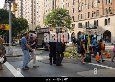 Passanten und Ersthelfer am Unfallort ein Schacht Feuer auf West 23rd Street in dem trendigen Chelsea-Viertel von New York Stockfoto