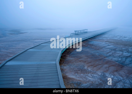 Boardwalk und Bank im Morgennebel um Grand Bildobjekte Spring im Yellowstone-Nationalpark, Wyoming, USA Stockfoto