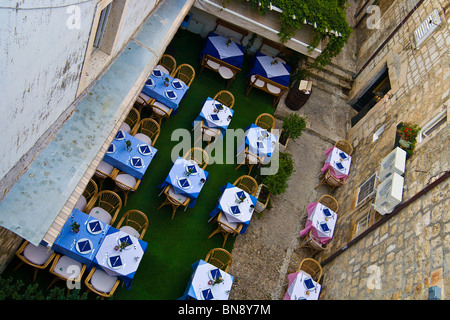 Ein Café im freien wartet auf Gäste ankommen, gesehen von der äußeren Stadtmauer der Festung von Dubrovnik, Kroatien. Stockfoto