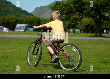 Junge, Radfahren auf einem Campingplatz in den Seen. Stockfoto