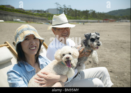 Paar mit ihren Hunden am Strand Stockfoto