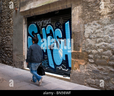 MAN WALKING VERGANGENHEIT Graffiti auf einem Verschluss in einem Barcelona Straße Stockfoto