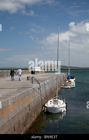 Paar, ein Spaziergang entlang der Anlegestelle in Ballyvaughan Hafen, Co. Clare, Irland Stockfoto