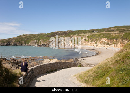 Blick auf einen ruhigen Strand mit mit Leuten im Sommer im Church Bay (Porth Swtan), Isle of Anglesey, North Wales, UK Großbritannien. Stockfoto