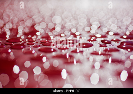 Nahaufnahme Makroaufnahme von Regentropfen auf einem roten Tisch