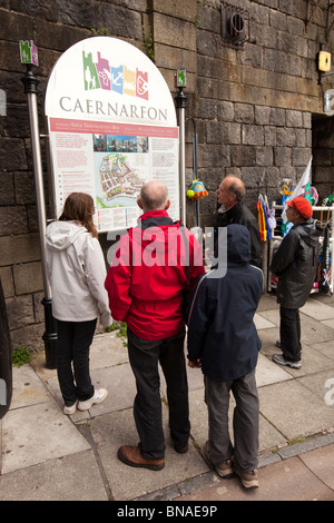 Großbritannien, Wales, Gwynedd, Caernarfon, Stadtzentrum, Touristen auf der Suche an Informationstafel und Karte Stockfoto