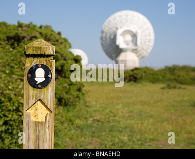 South West Coast Path Wegpunkt mit massiven Gerichte der Morwenstow GCHQ Satelliten Radiosender im Hintergrund Stockfoto