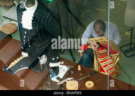 Ein Schneider legt gold Borte auf die Jacke eines königlichen Wachen Menschen. Savile Row. London W1. Vereinigtes Königreich. Stockfoto