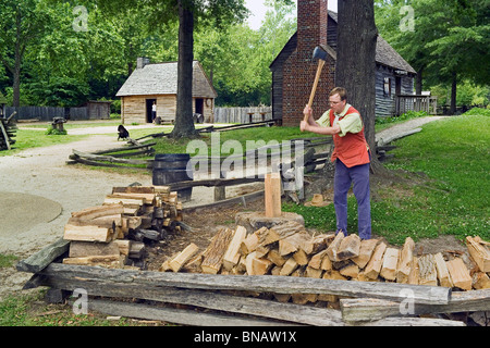 Ein Dolmetscher hackt Holz und bringt Leben in einem neu erstellten 1780er Jahren Bauernhof am lebende amerikanische Revolution-Geschichtsmuseum in Yorktown, Virginia, USA. Stockfoto