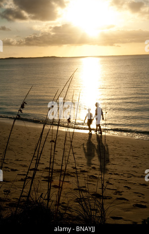 Paar am Strand bei Sonnenuntergang Stockfoto