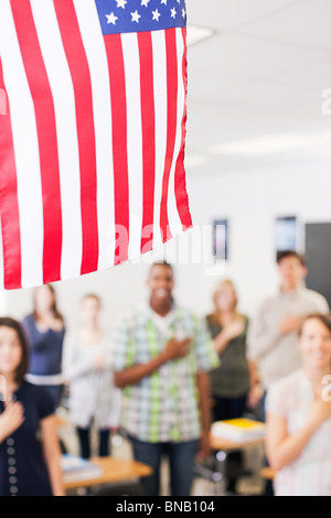 Gymnasiasten, die Treue zu schwören, um die amerikanische Flagge Stockfoto