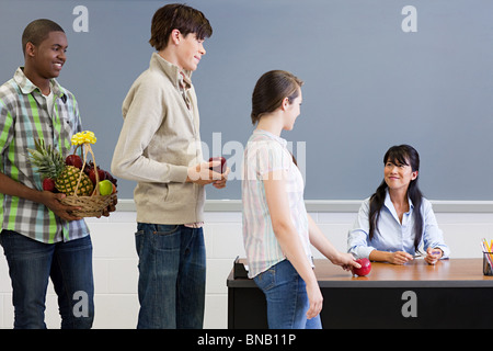 High-School-Schüler geben Lehrer einen Apfel Stockfoto