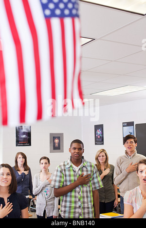 Gymnasiasten, die Treue zu schwören, um die amerikanische Flagge Stockfoto