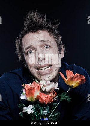 Studio-Porträt auf schwarzem Hintergrund einen lustigen expressive kaukasischen Mann Blumen betonte Stockfoto