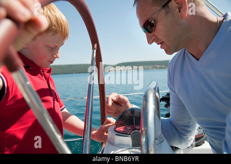 Mann erklärt junge Kompass auf yacht Stockfoto