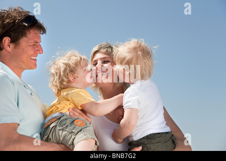 Familie mit Zwillingen küssen Stockfoto