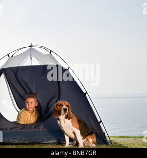 Junge mit Hund im Zelt auf dem Seeweg Stockfoto