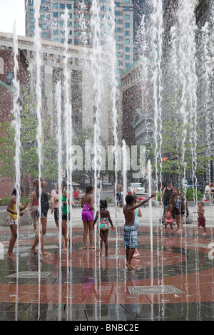 Boston, Massachusetts - Kinder spielen in einem Brunnen in der Nähe von Boston Waterfront an einem heißen Sommerabend. Stockfoto