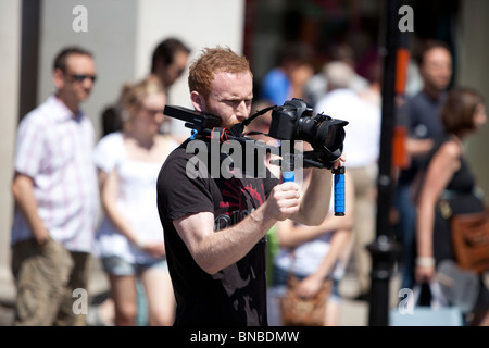 Aufnahmen von Videofilmen mit einer digitalen DLSR-Kamera, die auf einer Schulterstütze in London, England, Großbritannien montiert ist. Stockfoto