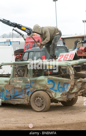 Mann, die Befestigung einer Delle im Dach eines Volvo mit einem Vorschlaghammer Stockfoto