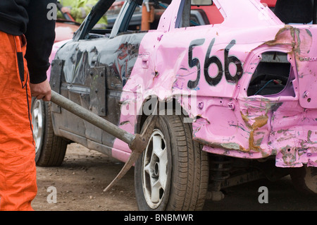 Banger Mechaniker Rennfahrer biegen mit einem Pick axe Junk-alte Spitzhacke Schrottauto mit Hammer Reparatur Reparatur Wartung Kuh Stockfoto