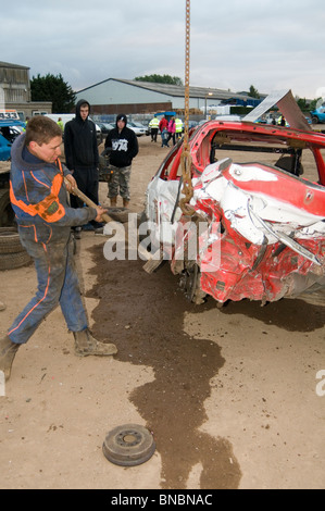 Banger Mechaniker Rennfahrer schlagen Schrott Junk-altes Auto mit Vorschlaghammer Vorschlaghammer reparieren Reparatur Wartung Cowboy Auto c Stockfoto