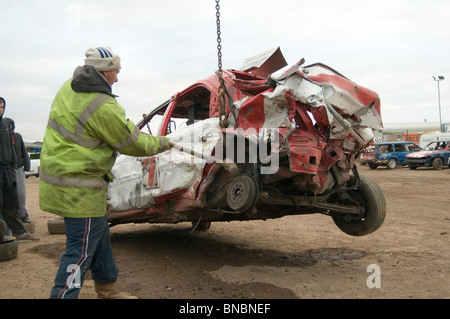 Mann einen Banger Rennwagen mit einem Vorschlaghammer zu reparieren Stockfoto