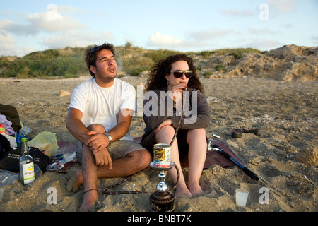 Paar Rauchen und relaxen am Strand von Dor in Israel Stockfoto