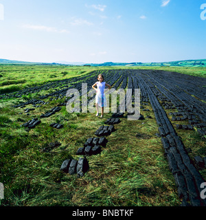 KLEINES MÄDCHEN FLANIEREN UNTER TROCKNUNG TORF ZIEGEL COUNTY KERRY IRLAND Stockfoto