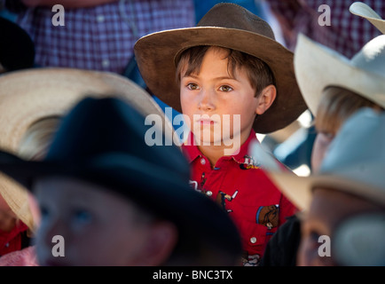 Ein 6-jähriger Junge steht unter anderen Kindern am Rodeo. Stockfoto