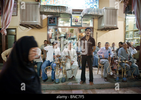 Ägyptische Männer Rauchen von Wasserpfeifen in einer Bar am Abend, der Markt, Aswan, Oberägypten Stockfoto