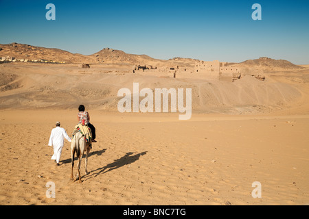 Ein Tourist auf einem Kamel nähert sich dem 7.Jahrhundert koptischen Kloster von St. Simeon, in der Nähe von Assuan, Oberägypten Stockfoto