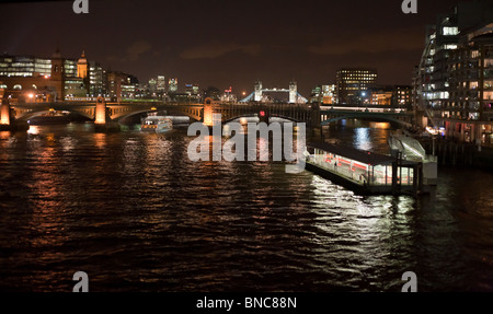 Thames River und East London Skyline bei Nacht... Die Themse mit der Tower Bridge im Hintergrund. Stockfoto