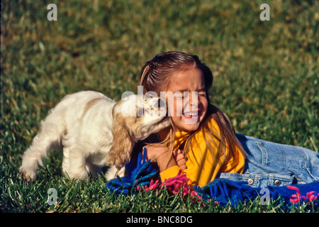 5-6 Jahr Jahre alt Kind Kinder Spaß beim Spielen mit Hund Mädchen verspielter Welpe Hund lecken Gesicht Seite Profil ansehen vorne HERR © Myrleen Pearson Stockfoto