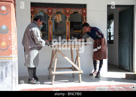 Zwei Männer spielen die traditionelle Brettspiel Carrom in den Straßen von Paro, Bhutan. Stockfoto