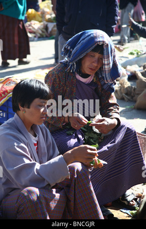 Frauen verkaufen ihr Gemüse und im Chat auf dem Markt platzieren in Paro, Bhutan. Stockfoto