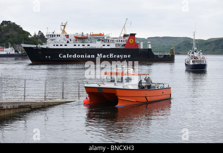 Eine Fähre in Oban mit zwei kleinere Boote vor Stockfoto