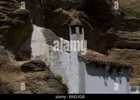 Ein weißes Haus gebaut in einer Höhle sitzen unter riesigen Felsen in Setenil de Las Bodegas Dorf, Provinz Cadiz, Andalusien, Spanien Stockfoto