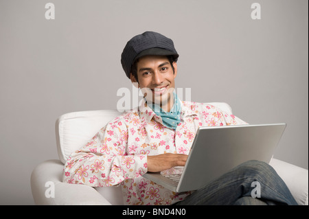 Porträt eines Schauspielers porträtiert Dev Anand und arbeiten auf einem laptop Stockfoto