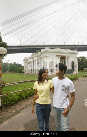 Paar mit einem Denkmal und Brücke im Hintergrund, James Prinsep Memorial, Vidyasagar Setu, Kolkata, Westbengalen, Indien Stockfoto