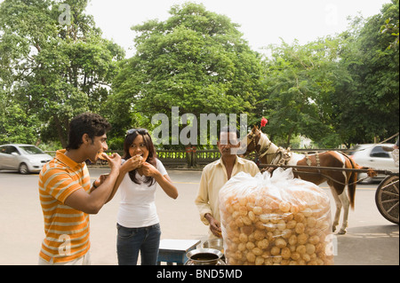 Anbieter mit indischen Snack Panipuri, ein paar auf einer Straße, Kolkata, Westbengalen, Indien Stockfoto